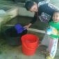 KETERANG GAMBAR :
Salah seorang ibu rumah tangga di kawasan jalan deliplantir terlihat sedang mengambil air hujan untuk kebutuhan dalam rumah tangganya. (Foto : Roy Prawira Pandia)