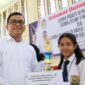 Pjs Bupati Toba, Dr Agustinus Panjaitan menyerahkan piala kepada Regina, Siswi SMP Budi Dharma Balige, juara 1 Lomba Pidato Berbahasa Inggris Tingkat SMP, se-Kecamatan Balige, Kabupaten Toba.