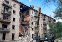 Para pegawai Kementerian Darurat bekerja di sisi gedung apartemen yang rusak setelah serangan rudal Ukraina di Luhansk, ibu kota wilayah Luhansk yang dikuasai Rusia, Ukraina timur, 7 Juni 2024. (Foto: via AP)