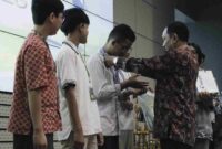 Kepala Departemen Matematika ITS Dr Didik Khusnul Arif SSi MSi memberikan penghargaan kepada salah satu pemenang OMITS 18th kategori SMP. (Foto: its.ac.id) 
