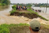 Warga menyaksikan tanggul Sungai Tuntang jebol di Desa Trimulyo, Guntur, Demak, Jumat (3/4/2026), yang memicu banjir hingga 1 meter dan merendam permukiman. (Foto: Muhammad Miftahul Khoir/ NUOnline Jateng)
