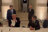 Momen Presiden AS Donald Trump menandatangani memorandum perjanjian damai dengan Iran dalam sebuah seremoni di Istana Versailles, Prancis, yang disaksikan langsung oleh Presiden Prancis Emmanuel Macron. (gambar: detik.com) 